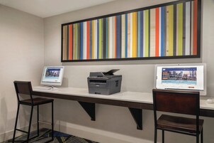 Un espacio de trabajo con dos escritorios, cada uno con una computadora e impresora.