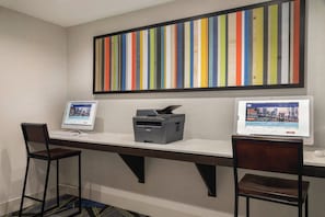 A workspace with two desks, each with a computer and a printer.