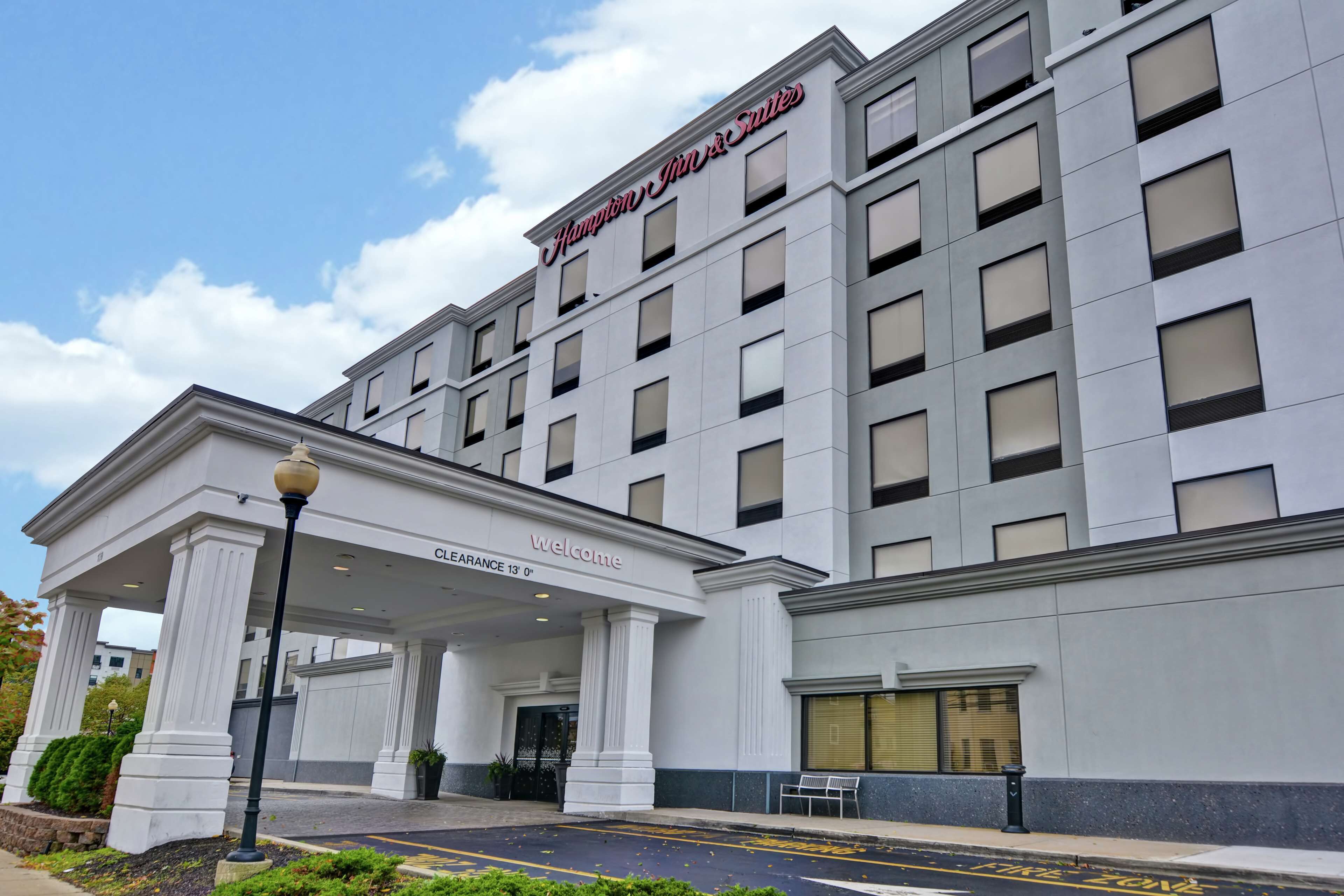 A hotel entrance with a clear entrance, a sign reading "Welcome", and a "Clearance 13' 0" sign.