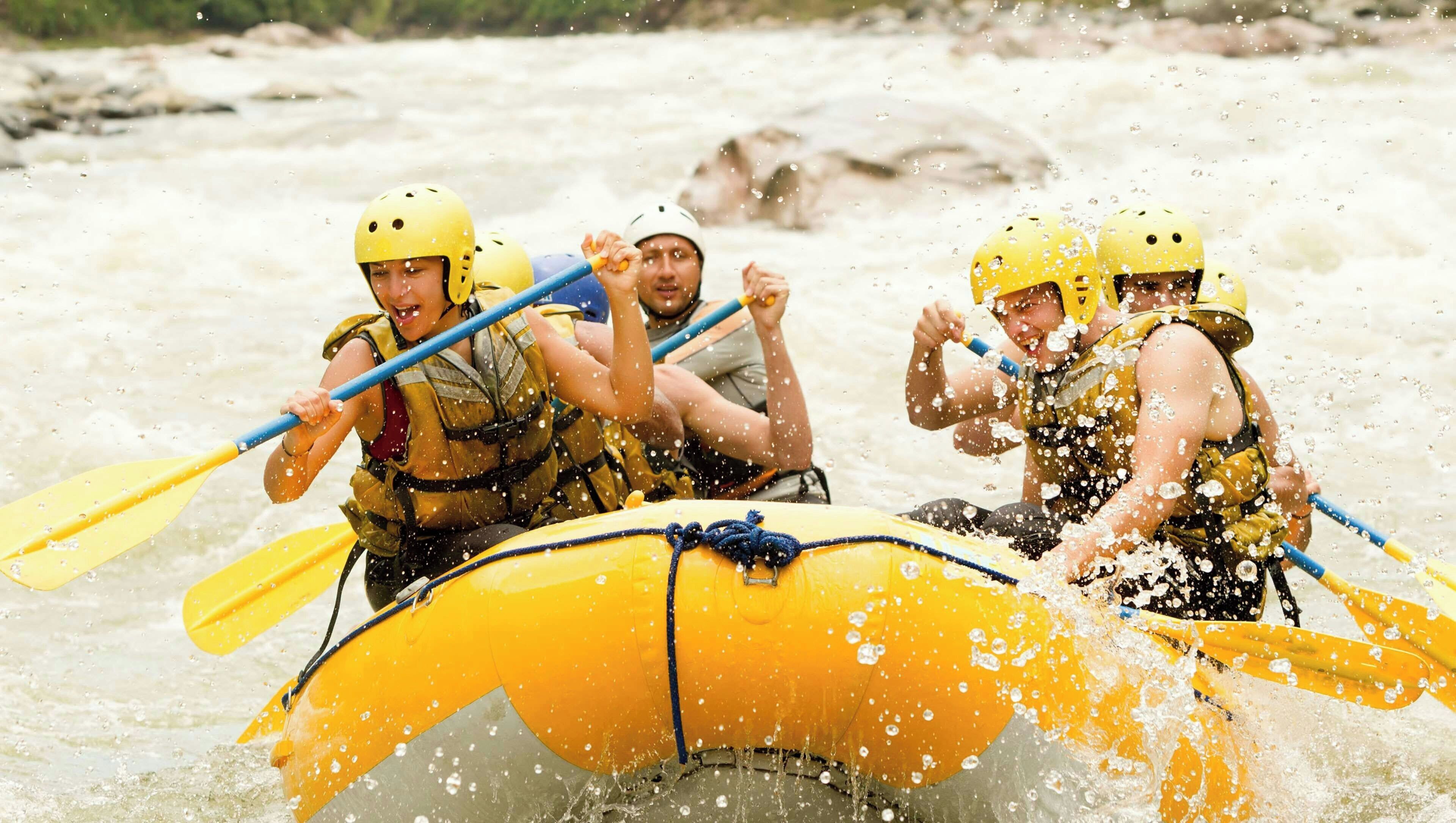 Un gruppo di persone su una zattera gialla che naviga in un fiume.