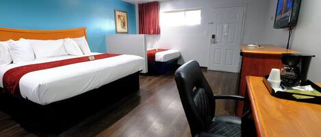 Une chambre d’hôtel avec un lit, un bureau, une chaise, une télévision et une fenêtre.