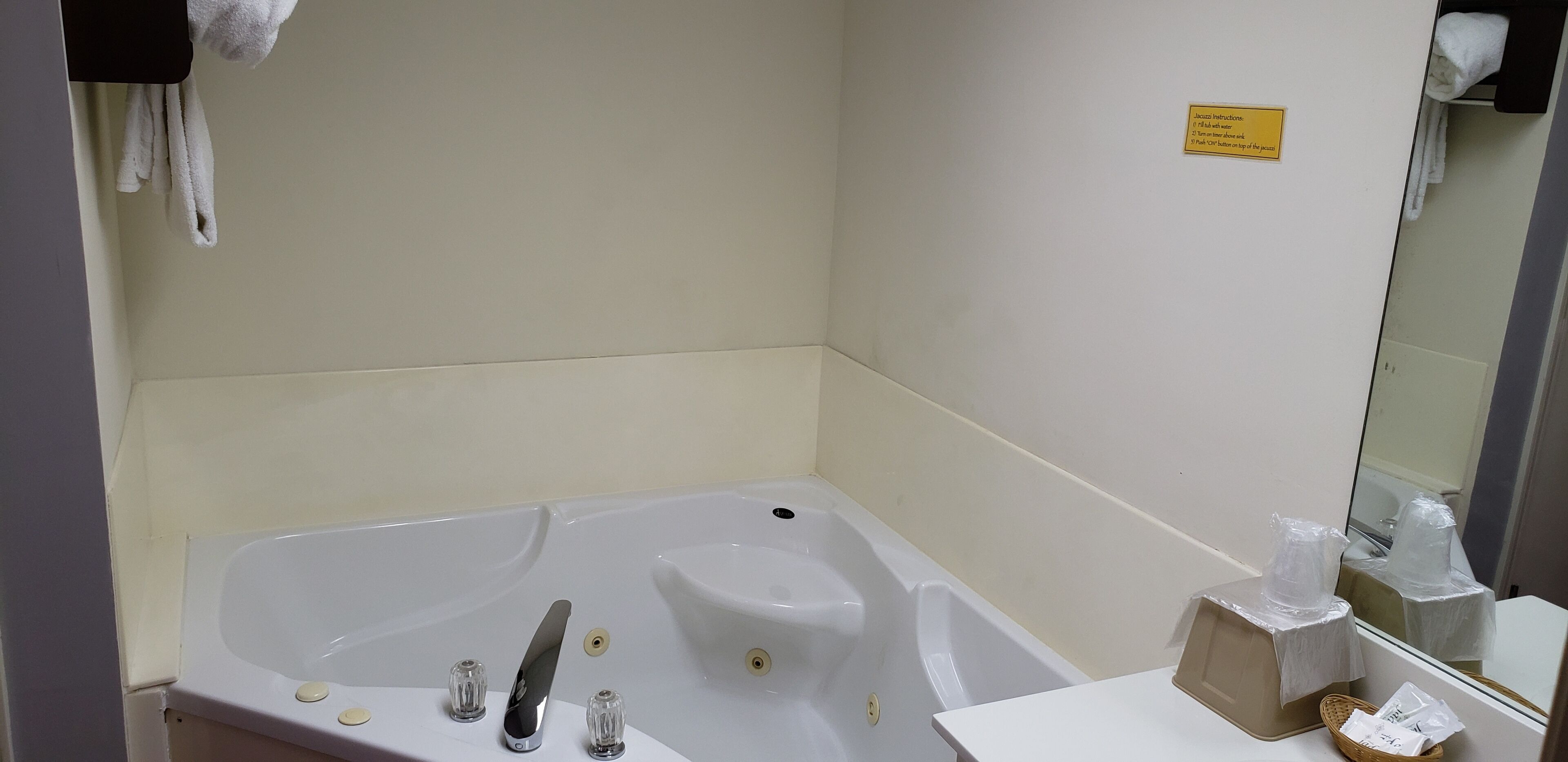 Un baño con bañera, lavabo, espejo y toallero.