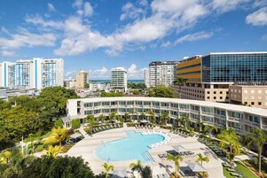 Un hotel con piscina, rodeado de vegetación y edificios modernos.