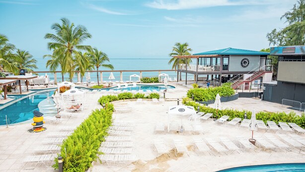A resort pool area with multiple sun loungers, a small pool, and a view of the ocean. - Hyatt Centric San Juan - Isla Verde (Carolina)