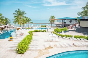 A resort pool area with multiple sun loungers, a small pool, and a view of the ocean. - Hyatt Centric San Juan - Isla Verde (Carolina)