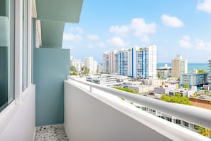 Varanda com vista para a paisagem urbana, incluindo edifícios altos e céu claro.