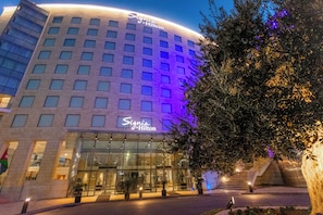 A hotel with a modern facade, large windows, and a sign that reads "Signia by Hilton".