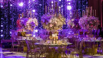 A formal dining setup with a table set for multiple guests, surrounded by chairs.