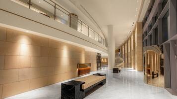 A spacious lobby with a marble floor, a reception desk, and a seating area.