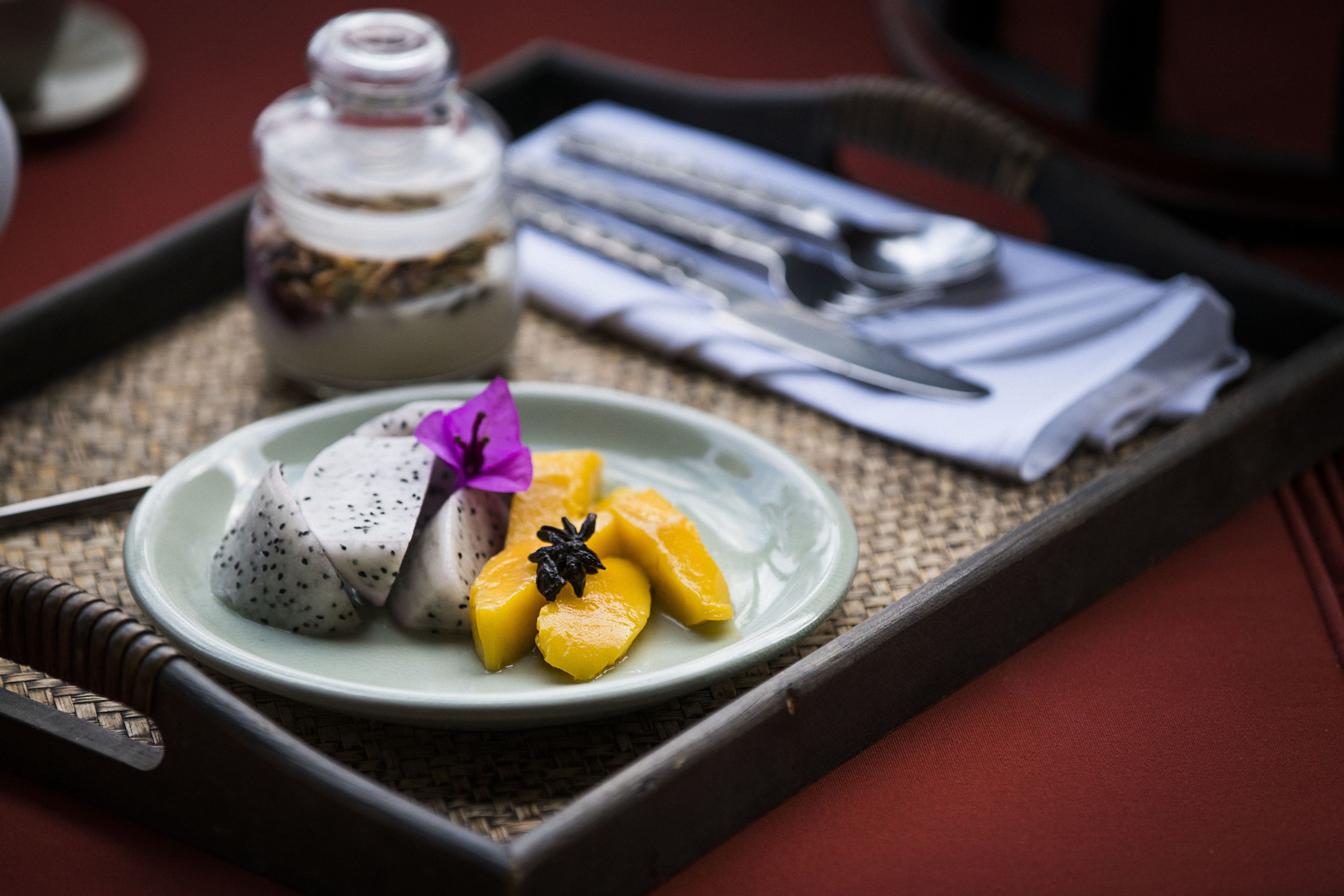 A tray with a plate of food, a bottle, and cutlery.