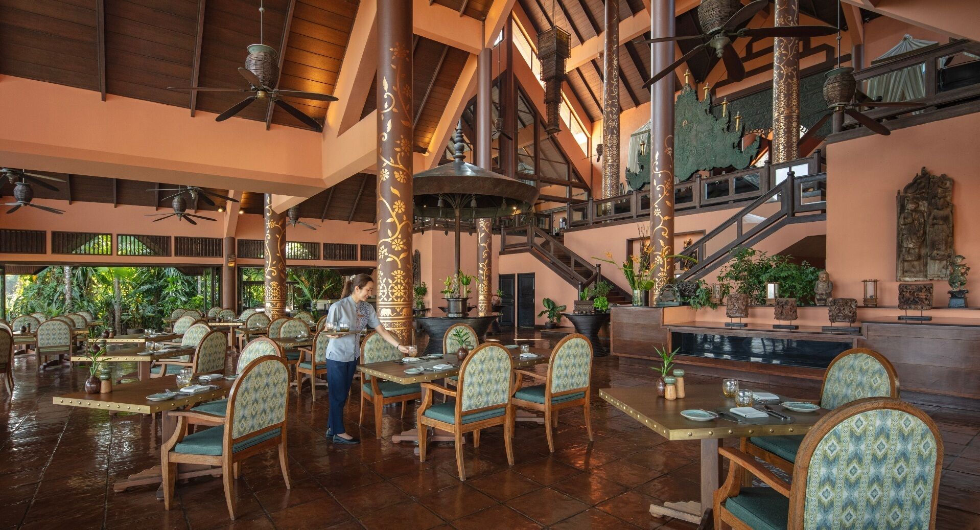 Un comedor interior amplio con techos altos, vigas de madera y numerosas mesas y sillas.