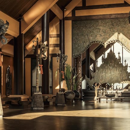 A traditional interior with high ceilings, ornate columns, and a central altar.