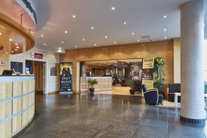 A hotel lobby with a reception desk, seating area, and a sign for a conference suite. - Future Inns Cardiff Bay (Cardiff)