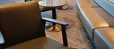 A modern lounge area with a sofa, chairs, and tables.