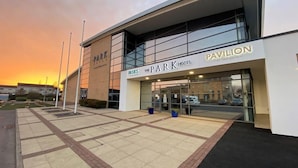 A modern hotel with a large glass facade, named 'The Park Hotel' with a 'Pavilion' sign.