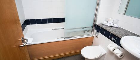 Un baño con bañera, inodoro y lavamanos.