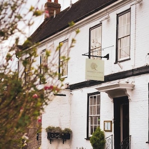 A white building with a sign reading "Warren Lodge" and a black door. - Warren Lodge Hotel (Shepperton)