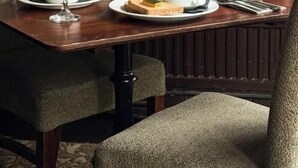 Une table à manger dressée avec des assiettes, des verres et un bol de soupe.