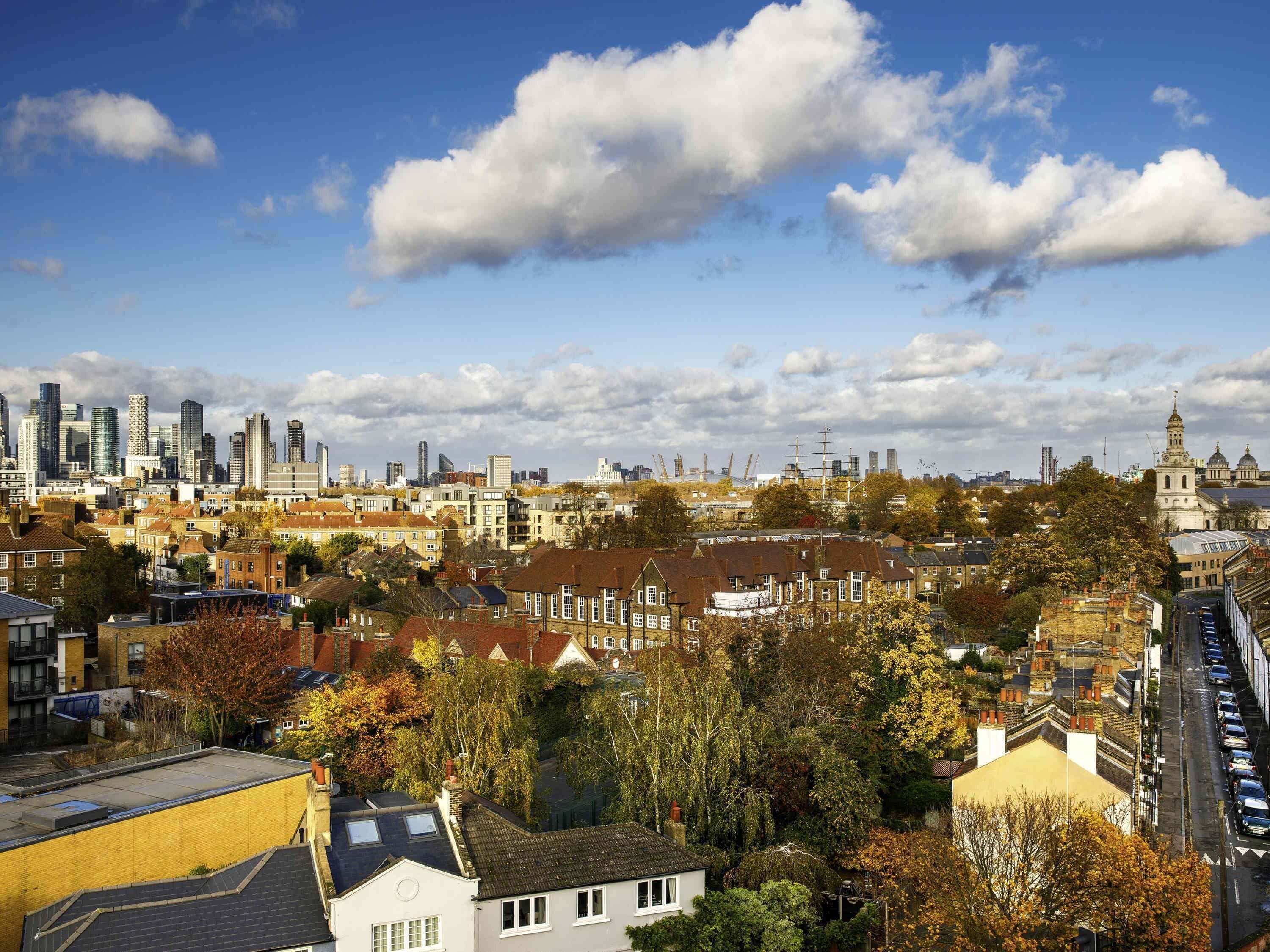A cityscape with a mix of modern and traditional buildings, a prominent church, and a clear sky.
