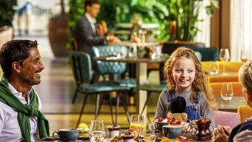 Enjoy a meal at this inviting dining area, complete with a round table set for a meal, featuring a variety of dishes and beverage service.