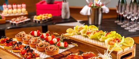 A buffet table with various appetizers, including skewers, salads, and breaded items.