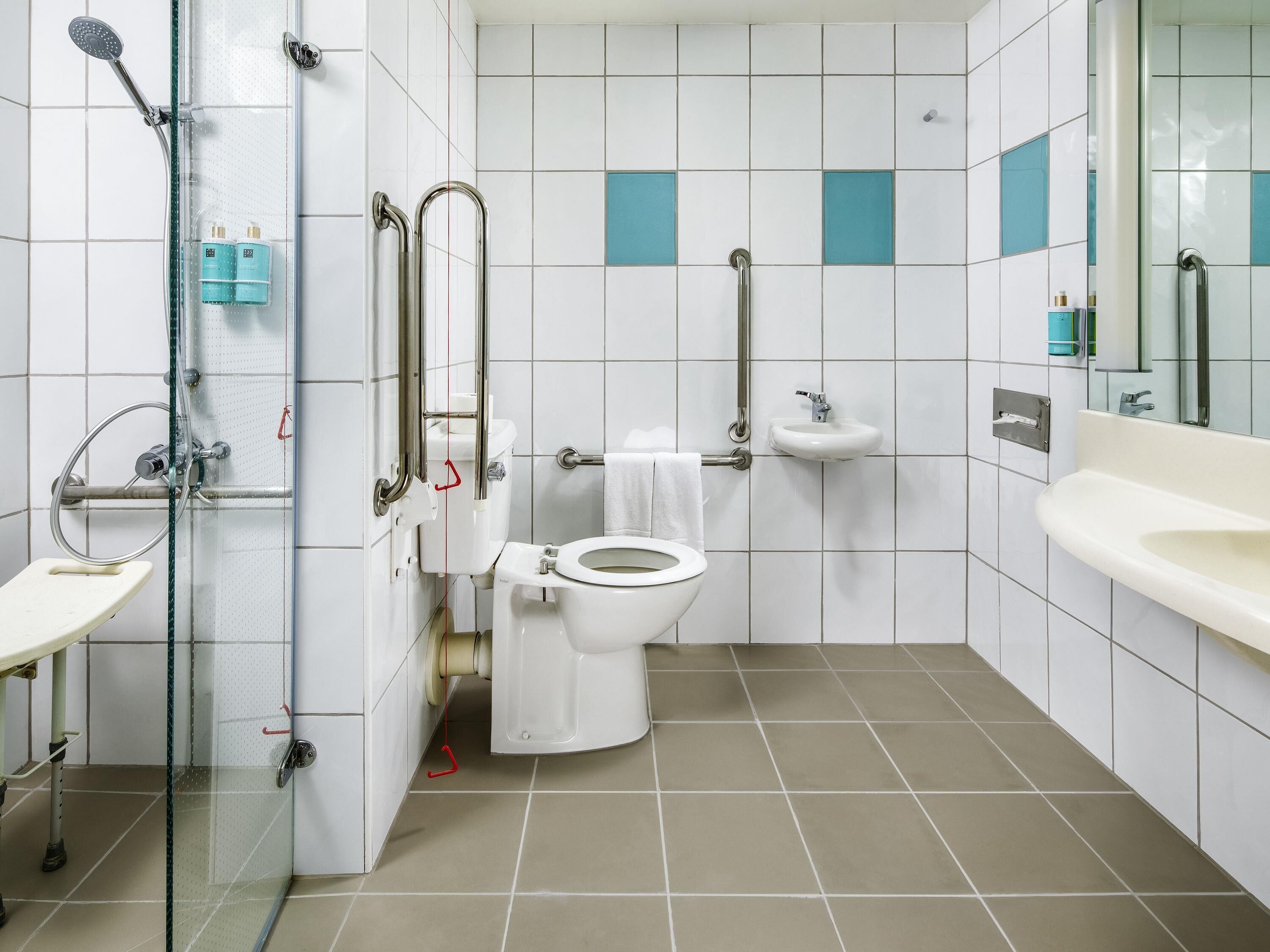 A bathroom with a toilet, sink, and shower.