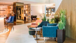 A modern interior with seating, a counter, and a wooden wall. - Novotel Le Havre Centre Gare (Le Havre)