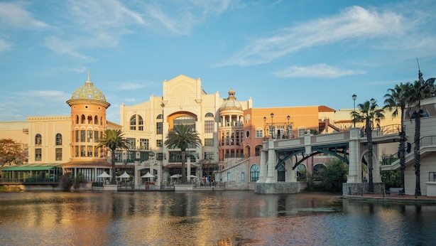 A waterfront hotel with a bridge, reflecting buildings, and a calm river.