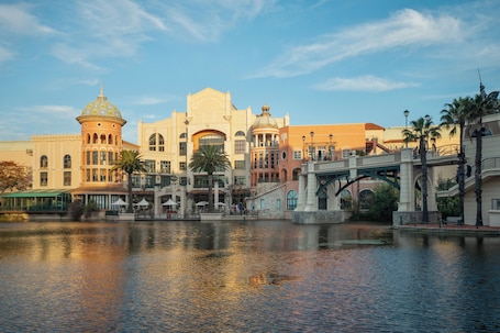 A waterfront hotel with a bridge, reflecting buildings, and a calm river.