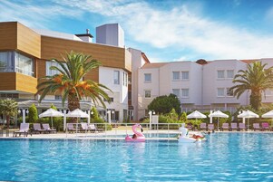 Una piscina techada, una piscina al aire libre de temporada, sombrillas