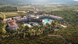 Een resort met meerdere gebouwen, een zwembad en veel groen eromheen.
