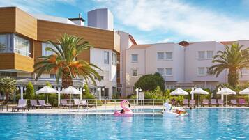 Una piscina techada, una piscina al aire libre de temporada, sombrillas