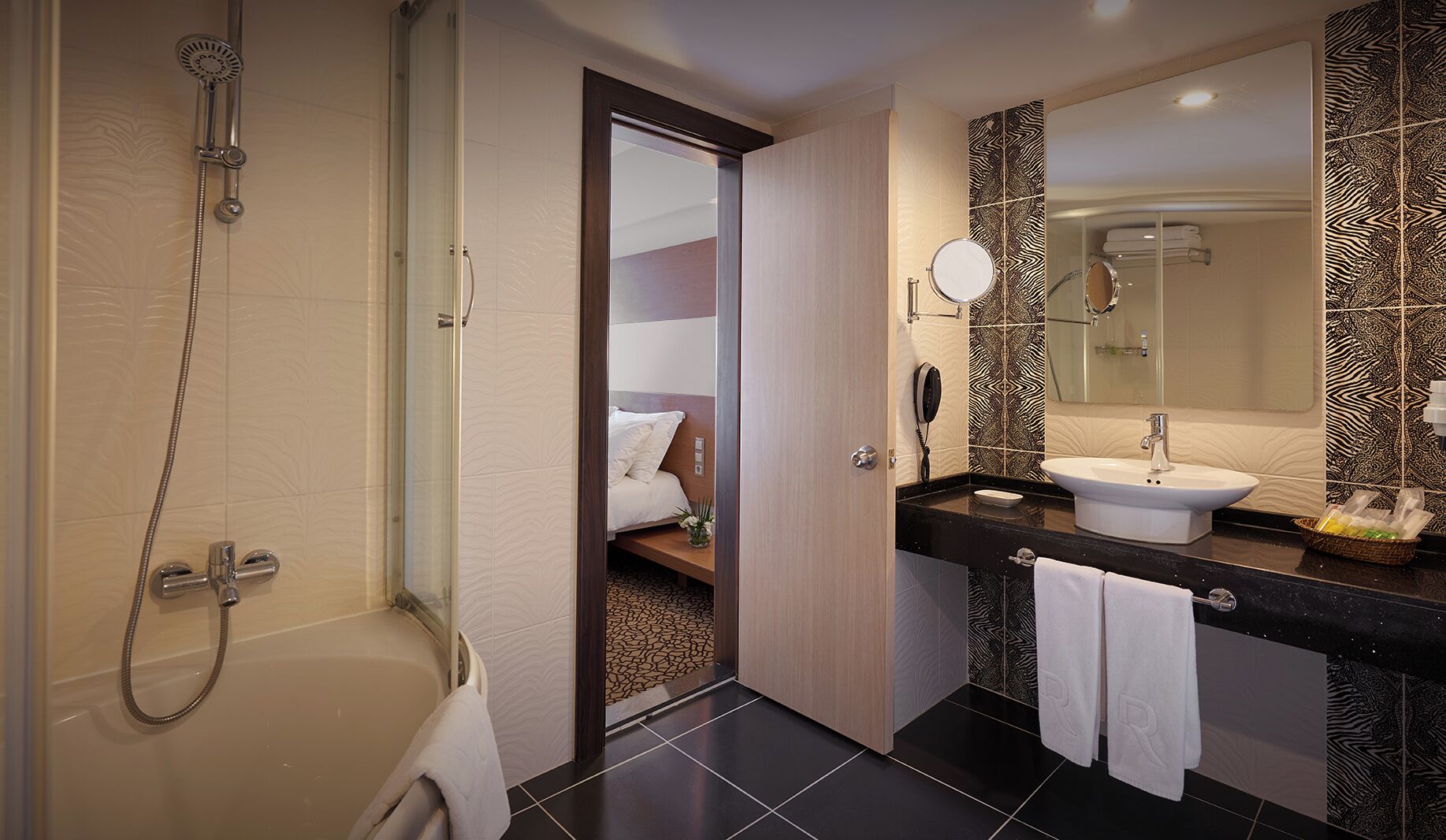 Un baño moderno con ducha, lavamanos y espejo.