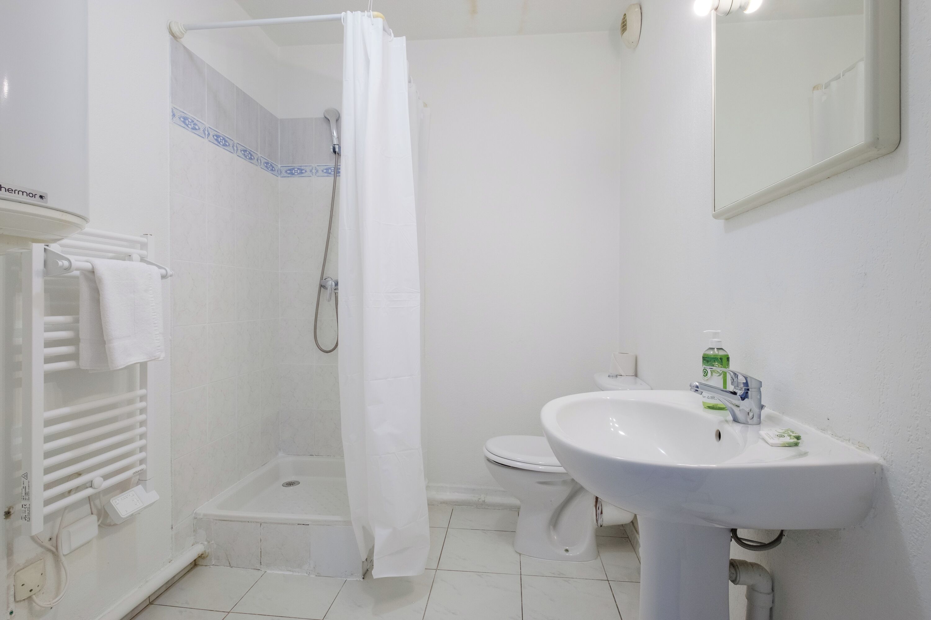 A bathroom with a shower, toilet, and sink.