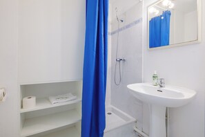 Familie studio | Badkamer | Een douche, gratis toiletartikelen, een haardroger, handdoeken