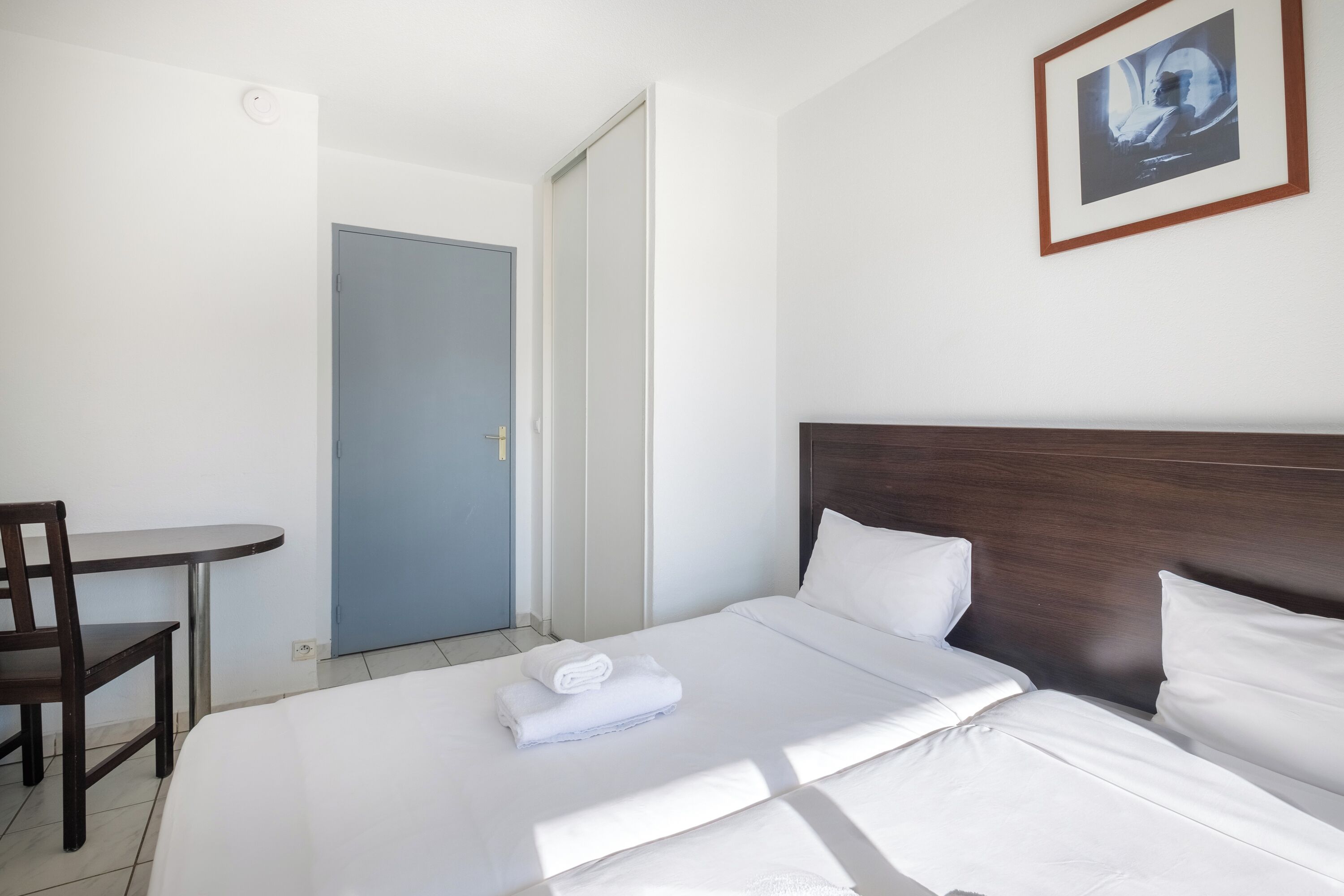 Una habitación de hotel con una cama, un escritorio y una silla.
