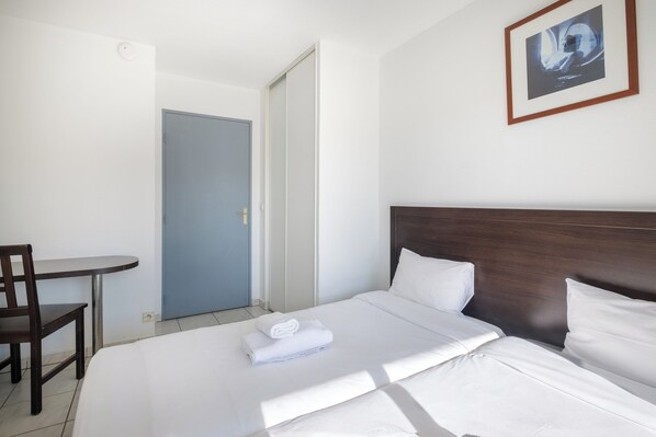 A hotel room with a bed, a desk, and a chair. - ResidHotel Cannes Festival (Cannes)
