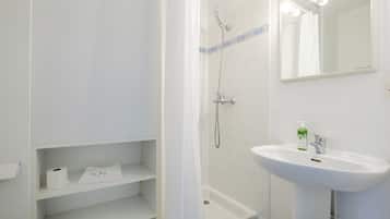 Un baño con ducha, lavabo y espejo.