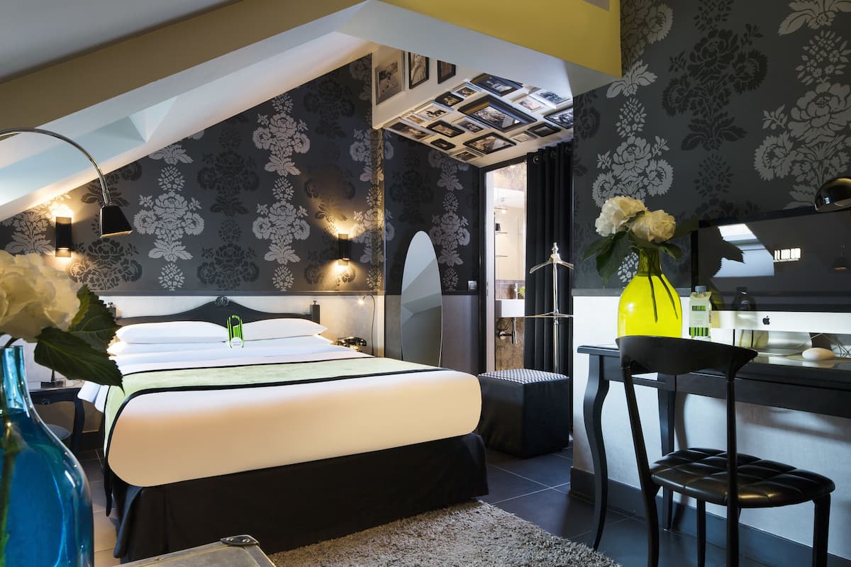 A modern bedroom with a large bed, a desk, and a chair.