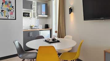 Une cuisine moderne équipée d’un four à micro-ondes, d’une bouilloire et d’une machine à café, le tout posé sur le plan de travail.