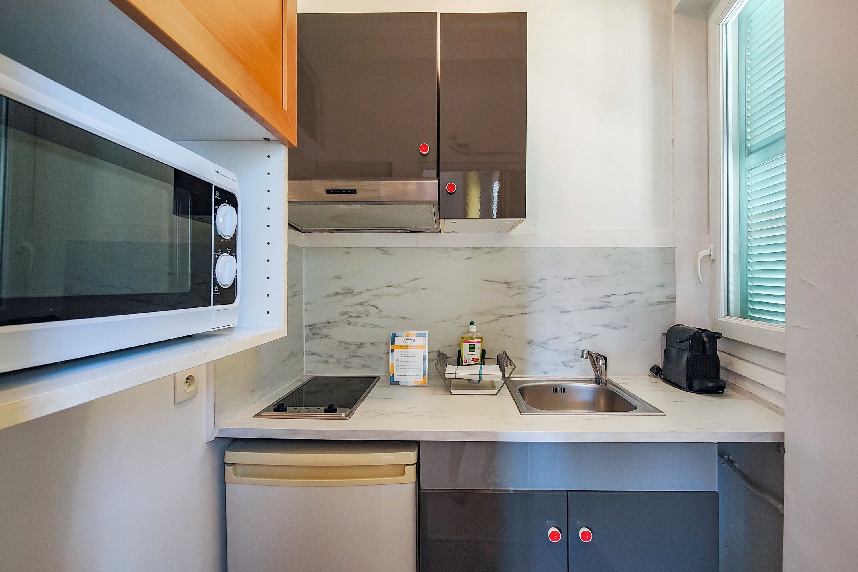 A compact kitchen with a microwave, stove, sink, and a dishwasher.