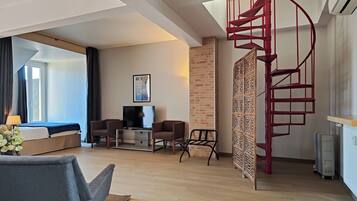 Relax in a spacious room with a large bed, flat-screen TV, and cozy seating area.
