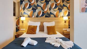 Een hotelkamer met een groot bed, twee nachtkastjes, een muur met een geometrisch patroon en een schilderij.