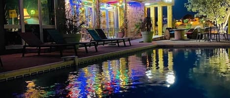 Una piscina al aire libre, sombrillas, tumbonas