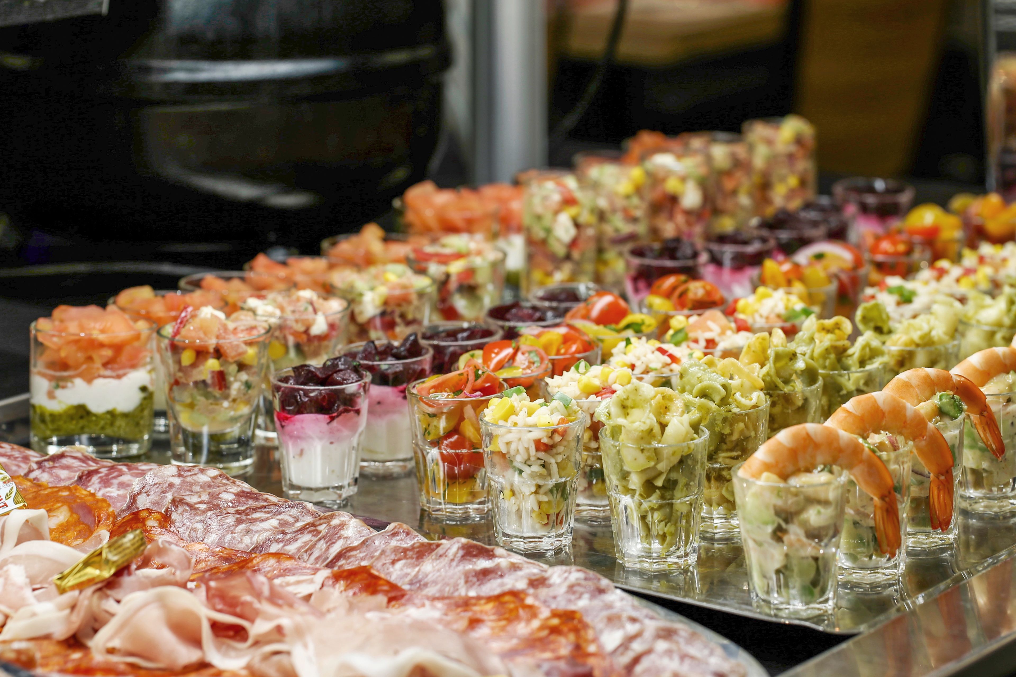 A variety of food items including shrimp, salads, and other appetizers arranged on a tray.