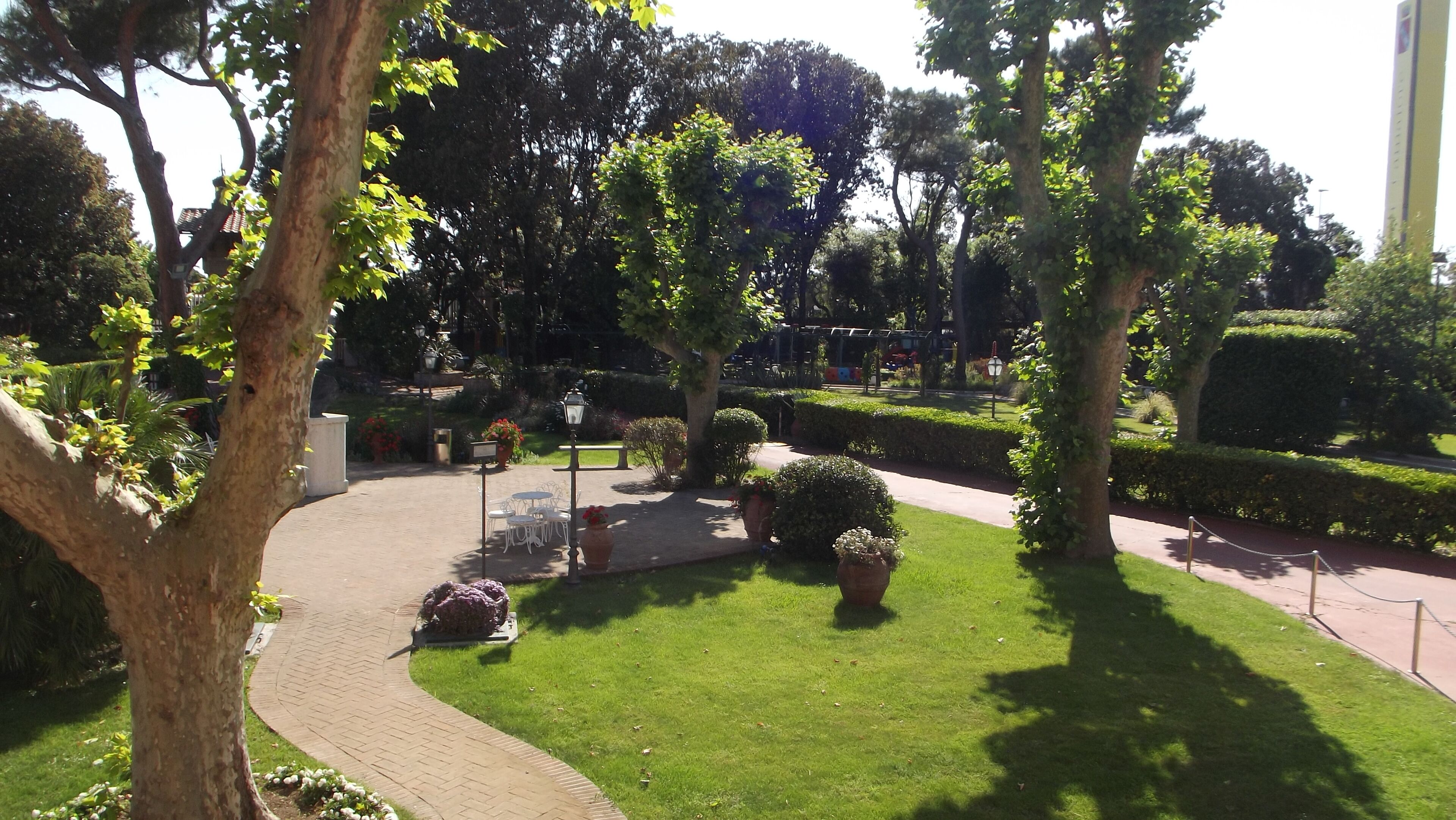 Un jardin aménagé avec des allées, des bancs et des plantes en pot.