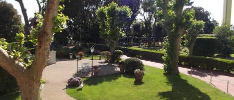 Un jardin aménagé avec des allées, des bancs et des plantes en pot.