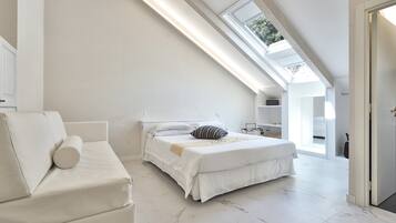 A modern bedroom with a skylight, a bed, a sofa, and a walk-in closet.