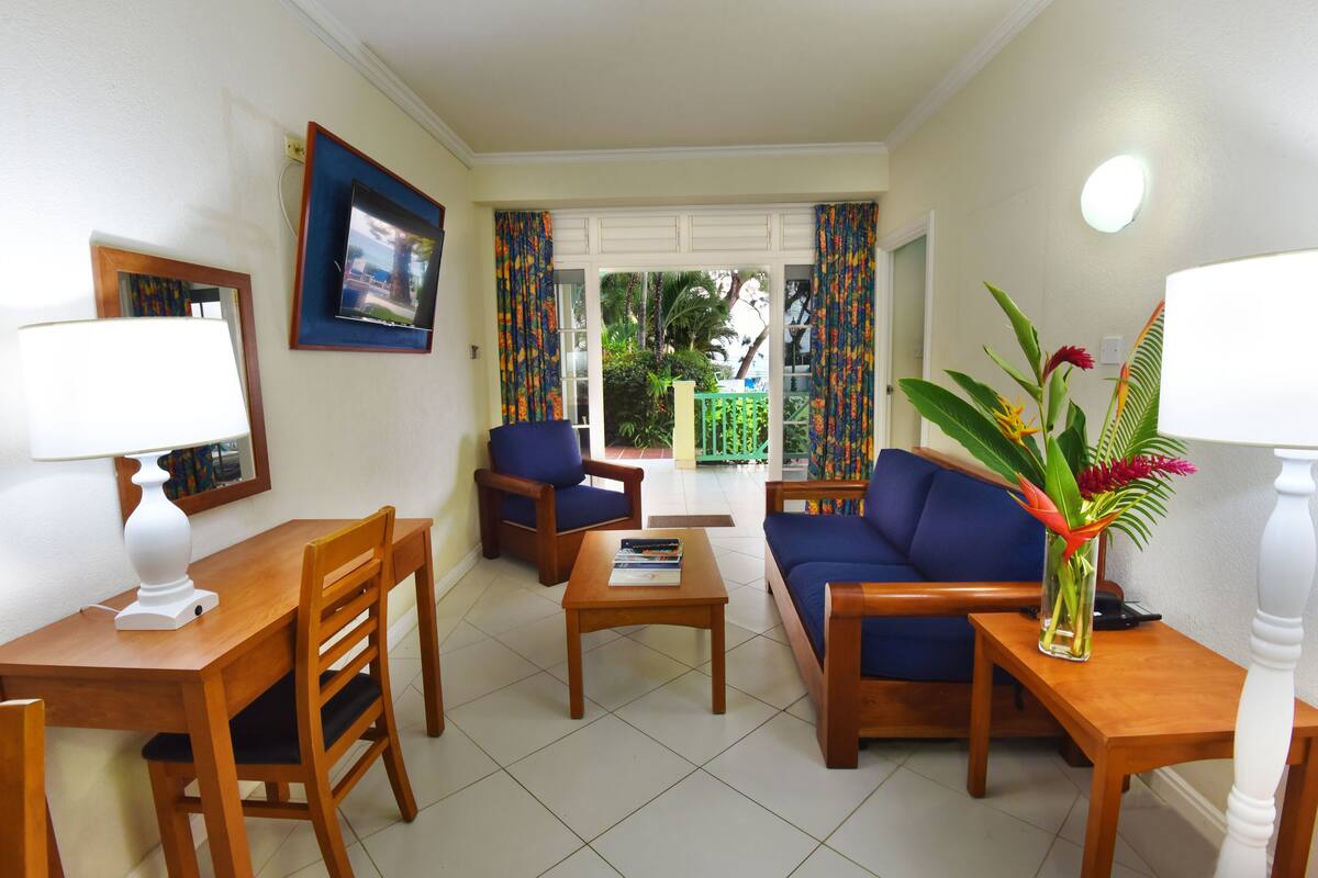 A living room with a sofa, chairs, a coffee table, and a TV.
