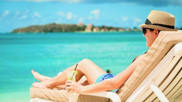 On the beach, white sand, sun loungers, beach umbrellas
